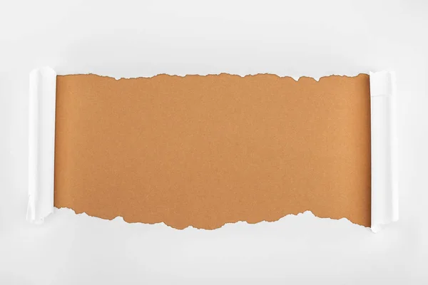 Ripped white paper with curl edges on brown background — Stock Photo