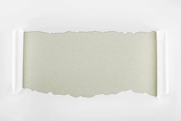 Papier texturé blanc déchiré avec bords bouclés sur fond gris — Photo de stock