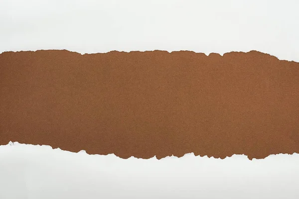 Papier blanc déchiqueté avec bords bouclés sur fond brun — Photo de stock
