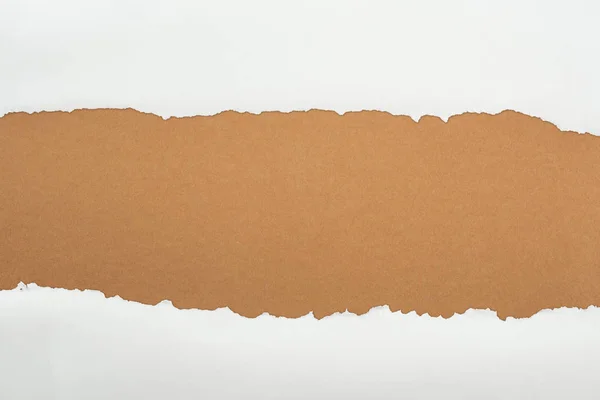 Papier texturé blanc déchiqueté avec espace de copie sur fond brun — Photo de stock