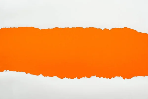 Ripped white textured paper with copy space on orange background — Stock Photo