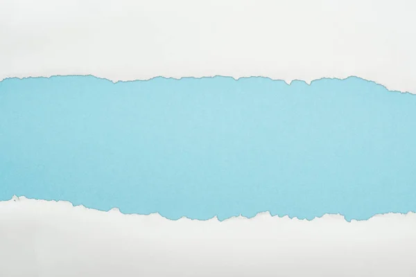 Zerlumptes weißes und strukturiertes Papier mit Kopierraum auf hellblauem Hintergrund — Stockfoto