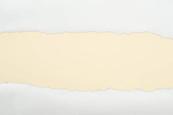 Papier texturé blanc déchiqueté avec espace de copie sur fond beige — Photo de stock