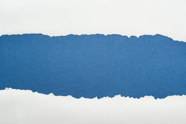 Papier texturé blanc déchiqueté avec espace de copie sur fond bleu profond — Photo de stock