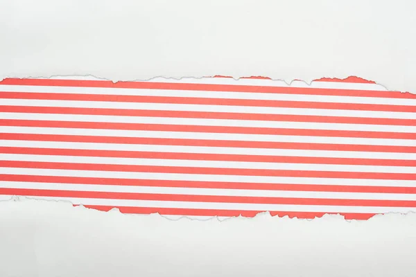 Papier texturé blanc déchiqueté avec espace de copie sur fond rayé rouge — Photo de stock