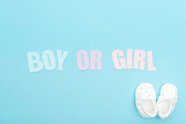 Vista superior de botas e menino ou menina lettering no fundo azul com espaço de cópia — Fotografia de Stock