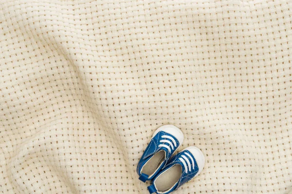 Vista dall'alto di scarpe da ginnastica blu su coperta beige con spazio copia — Foto stock