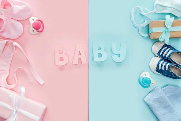 Top view of pacifiers, gifts, bonnets, hat, booties,sneakers and baby lettering — Stock Photo