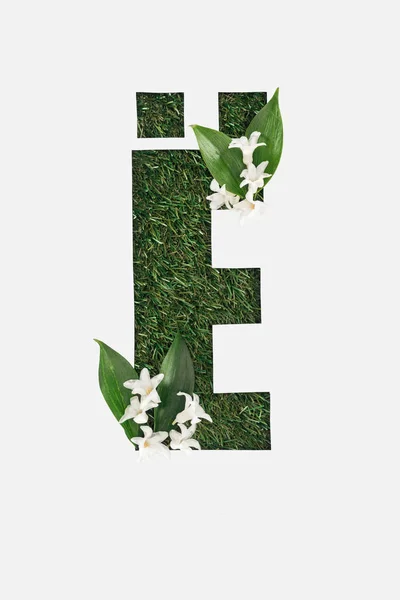 Top view of cyrillic letter with natural grass on background and white spring flowers with green leaves isolated on white — Stock Photo