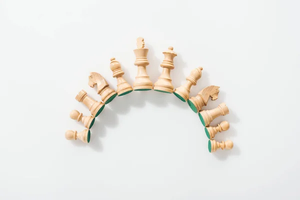 Top view of semicircle made of wooden chess figures on white background — Stock Photo