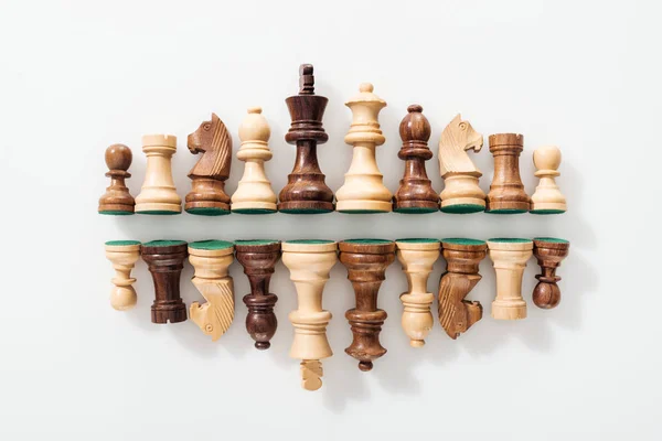 Top view of rows made of wooden chess figures on white background — Stock Photo