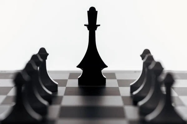 Selective focus of chessboard with black queen and pawns isolated on white — Stock Photo