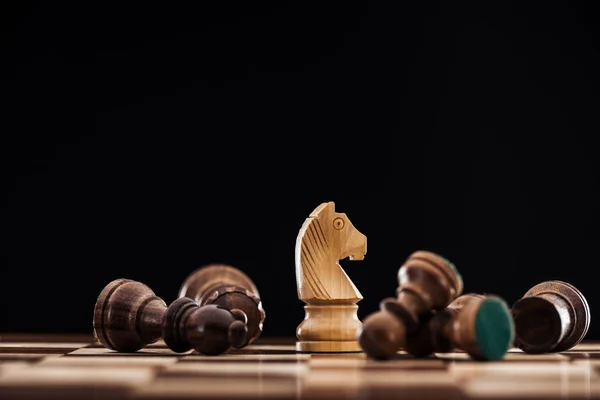 Foyer sélectif d'échiquier avec des figures en bois éparpillées et chevalier isolé sur noir — Photo de stock