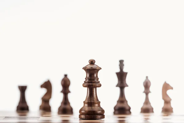 Selective focus of brown wooden queen on chessboard isolated on white — Stock Photo