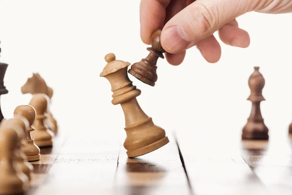 Частковий вид людини, що рухається з коричневим пішаком на шахівниці ізольовано на білому — стокове фото