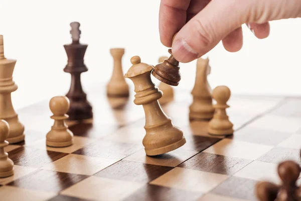 Visão parcial do homem fazendo movimento com peão marrom no tabuleiro de xadrez de madeira isolado no branco — Fotografia de Stock