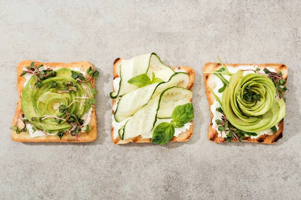 Draufsicht auf Toasts mit geschnittenem Gemüse auf Texturoberfläche — Stockfoto