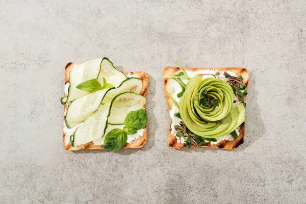 Top view of toasts with cut vegetables on textured surface — Stock Photo