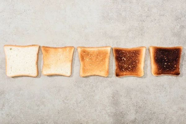 Top view of bread toasts on grey textured surface — Stock Photo