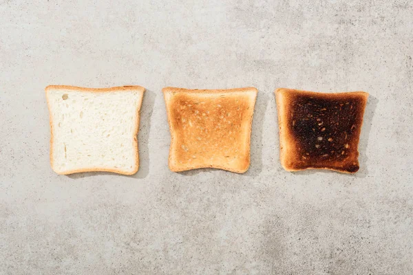 Top view of bread toasts on grey textured surface — Stock Photo