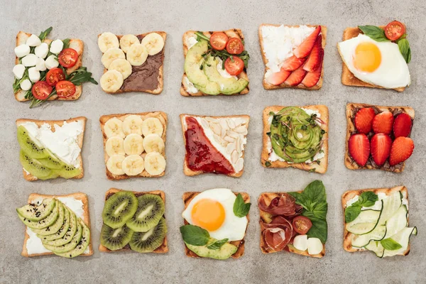 Vista dall'alto di pane tostato con uova fritte, verdure tagliate e frutta su superficie strutturata — Foto stock