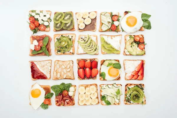 Vista superior de torradas com frutas cortadas, legumes e amendoins em branco — Fotografia de Stock