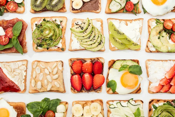 Vista superior de torradas com frutas cortadas, legumes e amendoins em branco — Fotografia de Stock