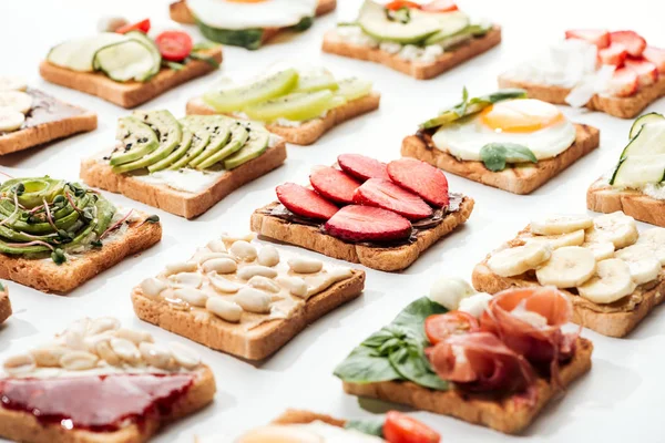 Toasts with cut fruits, fried egg and peanuts on white — Stock Photo