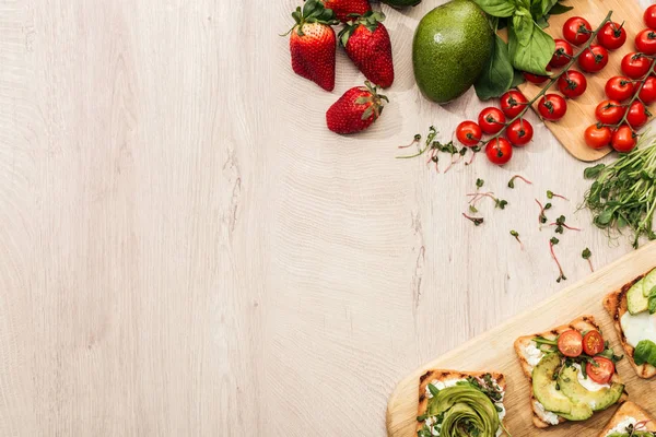 Vista superior de torradas com legumes e ingredientes em mesa de madeira com espaço de cópia — Fotografia de Stock