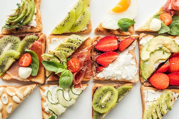 Sfondo di deliziosi toast a fette con frutta e verdura isolata su bianco — Foto stock