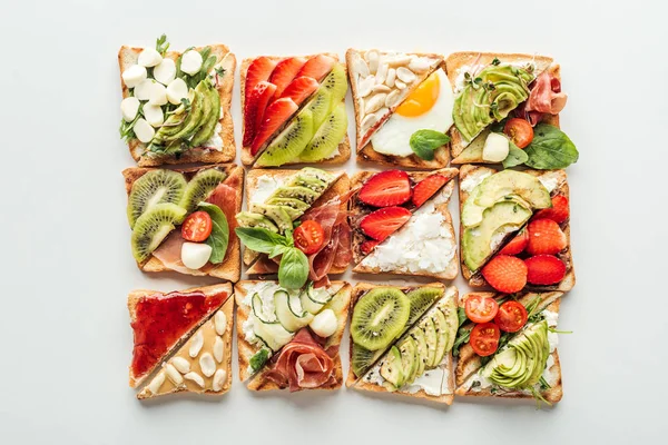 Top view of toasts with fresh fruits and vegetables isolated on white — Stock Photo