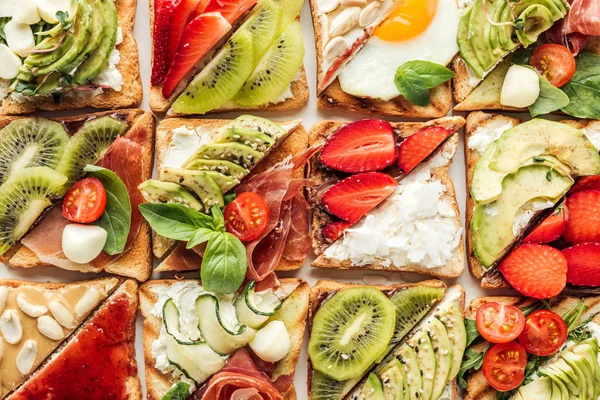 Фон смачних тостів з фруктами та овочами ізольовані на білому — стокове фото
