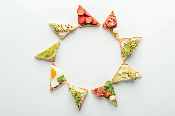 Top view of toasts with fruits and vegetables arranged in frame isolated on white with copy space — Stock Photo