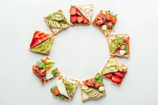 Vue de dessus des toasts aux fruits et légumes disposés dans un cadre isolé sur blanc avec espace de copie — Photo de stock