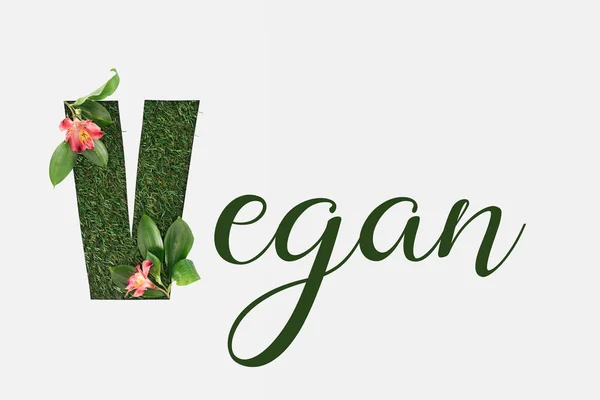 Ansicht von oben: grüner veganer Schriftzug mit Blättern und Alstromerieblüten isoliert auf weiß — Stockfoto