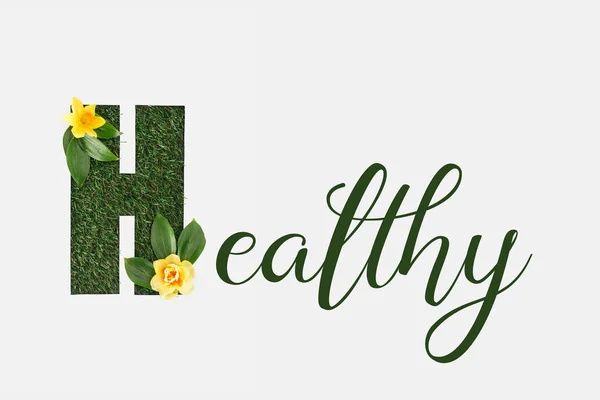 Top view of green healthy lettering with leaves and yellow daffodils isolated on white — Stock Photo