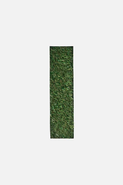 Top view of cut out I letter on green grass background isolated on white — Stock Photo