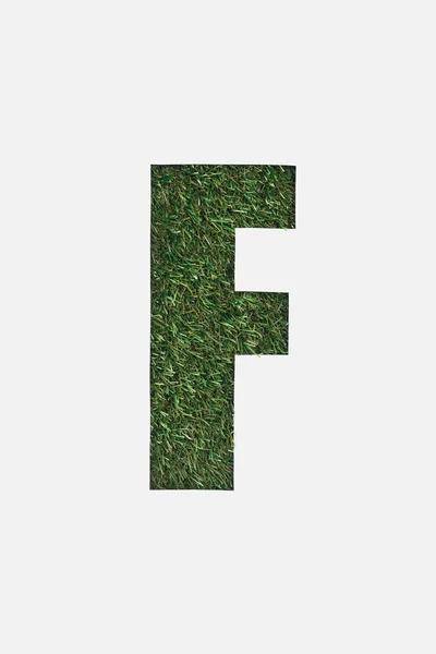 Top view of cut out F letter on green grass background isolated on white — Stock Photo