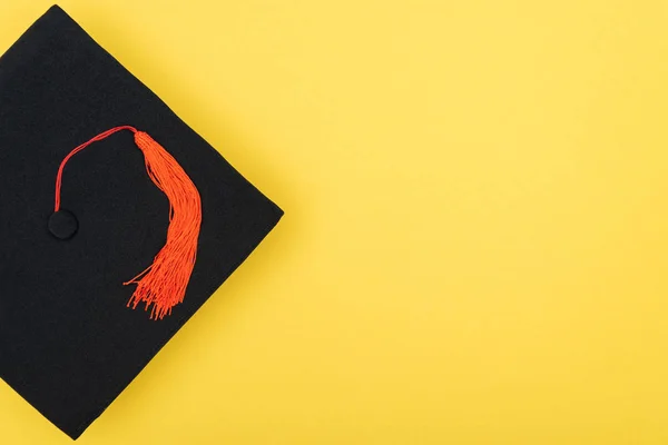 Top view of academic cap with red tassel isolated on yellow — Stock Photo