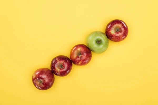 Vista superior de manzanas frescas maduras en la superficie amarilla - foto de stock