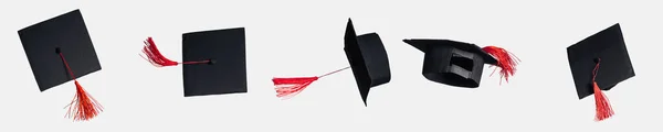 Panoramic shot of academic caps with red tassels isolated on white — Stock Photo