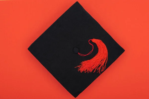 Top view of academic cap with tassel isolated on red — Stock Photo