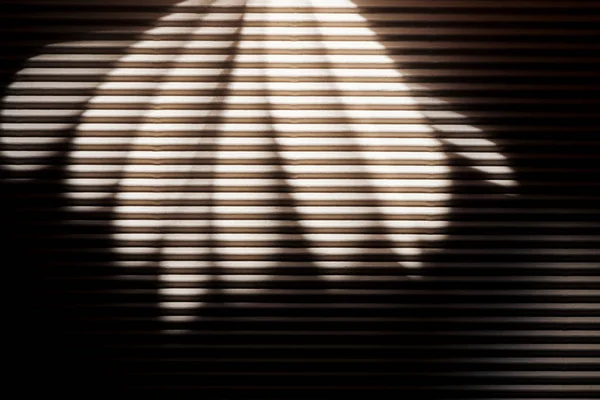 White rays on black textured surface in darkness — Stock Photo