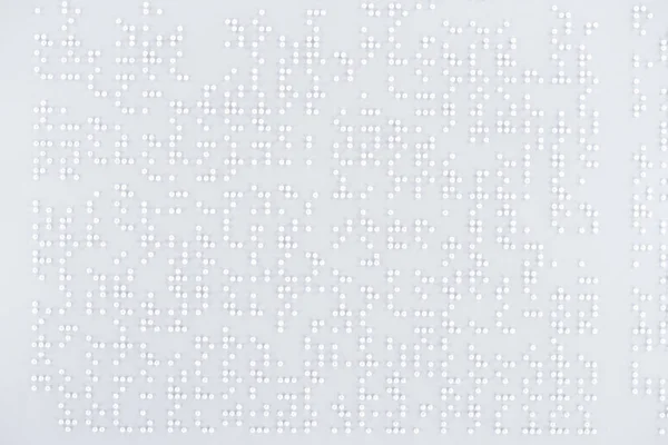 Верхний вид текста в международном коде Брайля на белой бумаге — стоковое фото