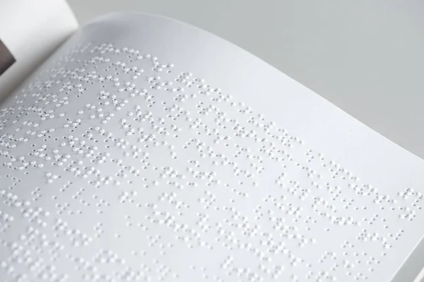 Vista de perto do texto em braille sobre papel branco isolado sobre cinza — Fotografia de Stock