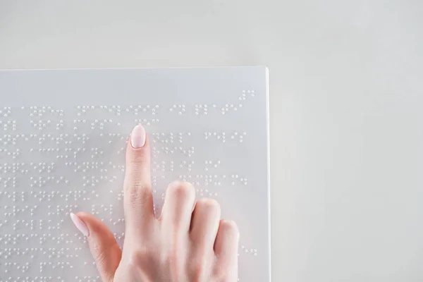 Vista superior da mulher jovem lendo texto braille no livro branco com espaço de cópia — Fotografia de Stock