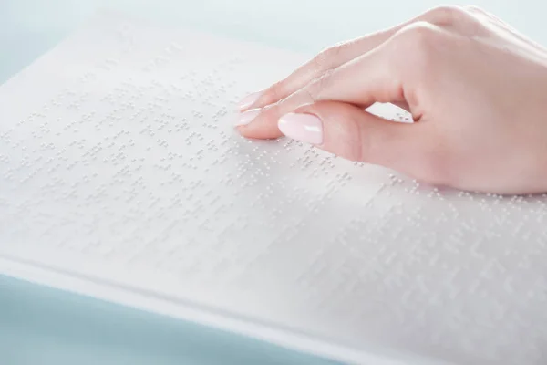 Visão de perto da jovem mulher lendo texto braille no livro branco — Fotografia de Stock