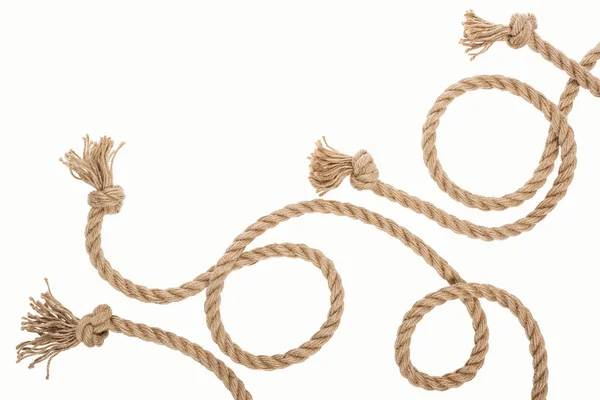 Коричневый джут и изогнутые веревки с узлами, изолированными на белом — стоковое фото