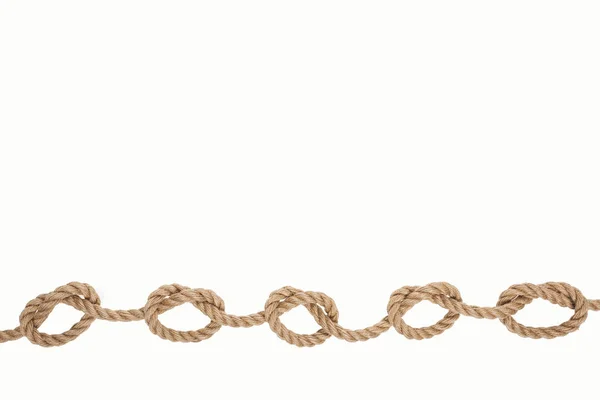 Морская коричневая веревка с морскими узлами, изолированными на белом — стоковое фото