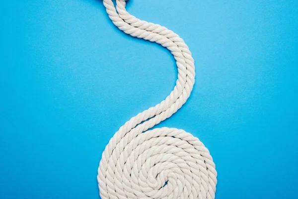 Long white waved and twisted ropes isolated on blue — Stock Photo